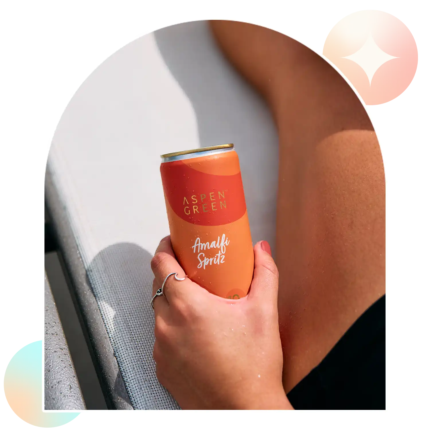 Hand holding refreshing Aspen Green Amalfi Spritz THC drink outdoors