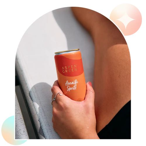 Hand holding refreshing Aspen Green Amalfi Spritz THC drink outdoors