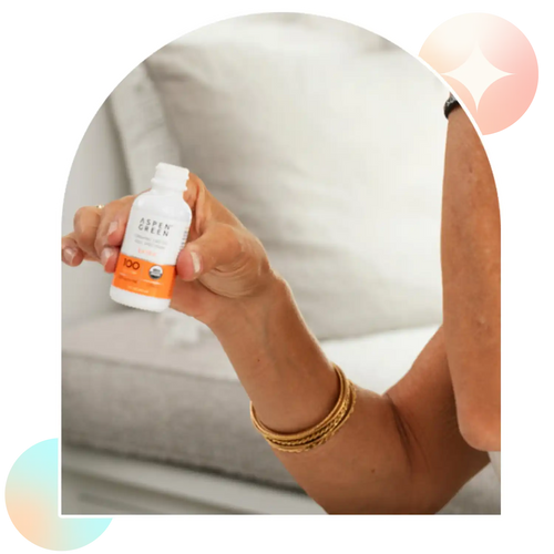 Woman holding Aspen Green Extra Citrus CBD oil bottle