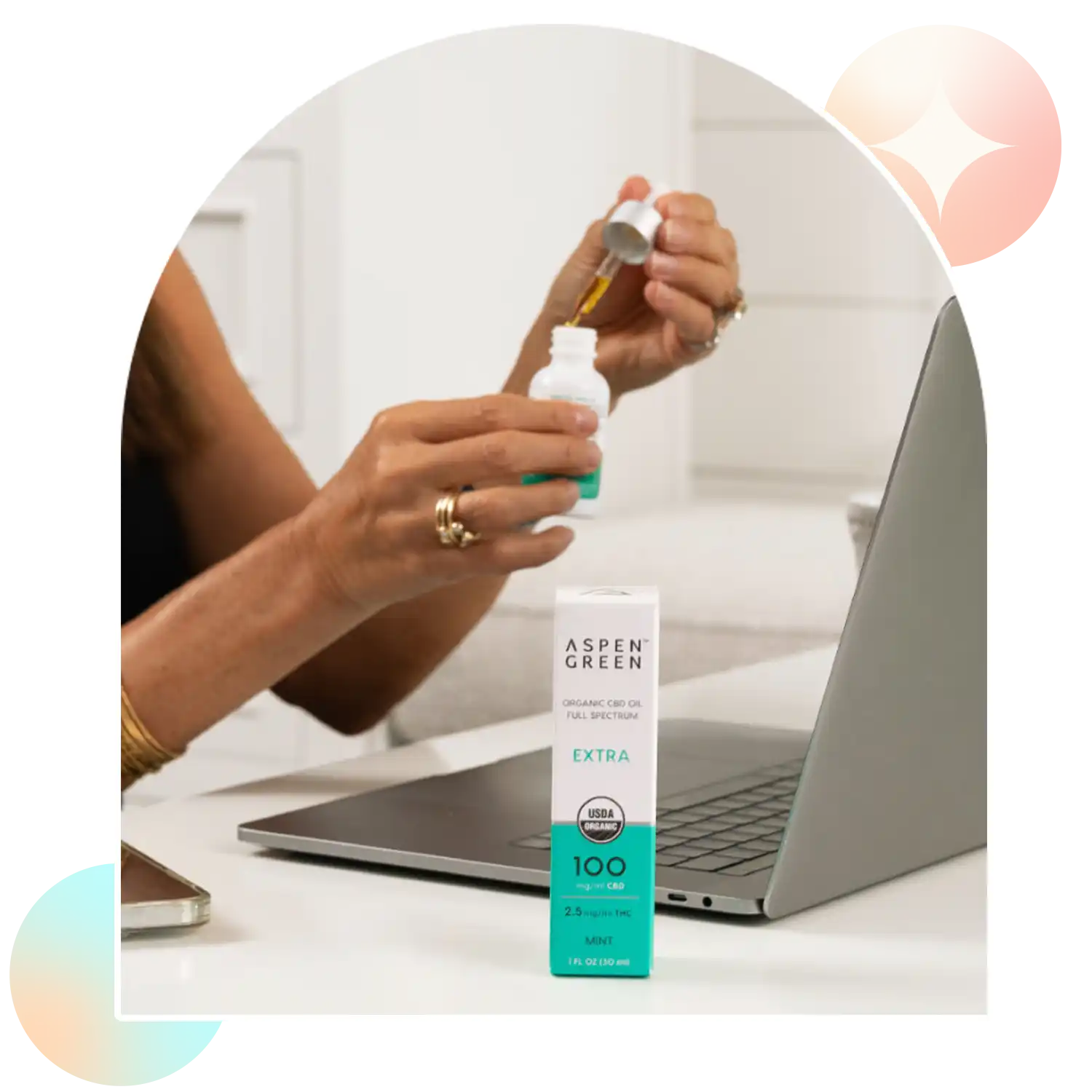 Woman using dropper of Aspen Green Extra Mint CBD Oil at desk