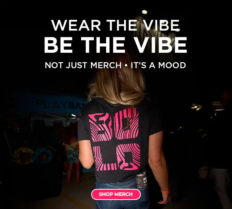 Person wearing a black BOLO t-shirt with a pink design, standing in a dimly lit setting.