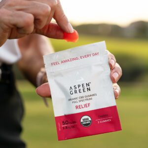 Woman grabbing CBD relief gummy from sample pack (closeup)