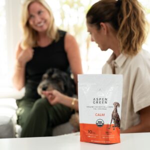 Woman Feeding Dog with Aspen Green Calm CBD Dog Chews Pouch in Foreground